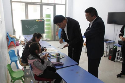 圖為北鎮(zhèn)市委副書記趙春剛和錦州市殘聯(lián)副理事長孟軍詢問殘疾兒童的學(xué)習(xí)生活情況