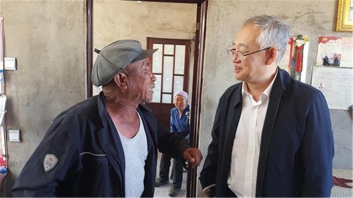 圖為于長源走訪貧困殘疾人家庭