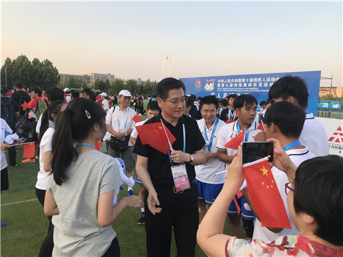 圖為志愿者與運(yùn)動(dòng)員一道慶祝勝利