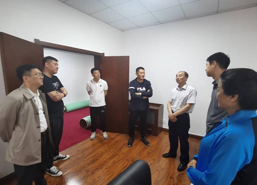 圖為市殘聯(lián)領(lǐng)導(dǎo)同教練員、工作人員交流