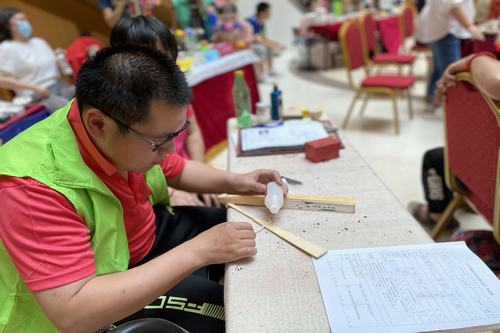 圖為自閉癥兒童現(xiàn)場(chǎng)制作手工折扇