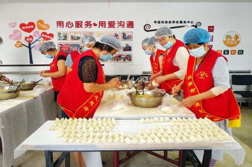 圖為志愿者為盲人朋友包餃子