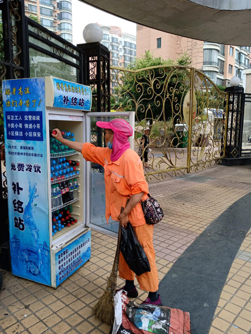 圖為環(huán)衛(wèi)工人享受到了酷暑中的清涼