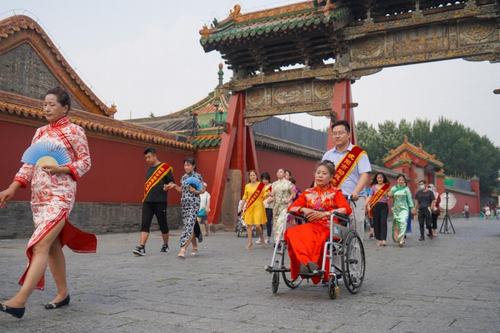 圖為志愿者協(xié)助身著旗袍的殘障女性體驗(yàn)盛京古韻文化