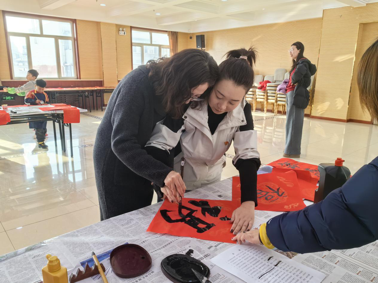 圖為書法家手把手教授志愿者書寫
